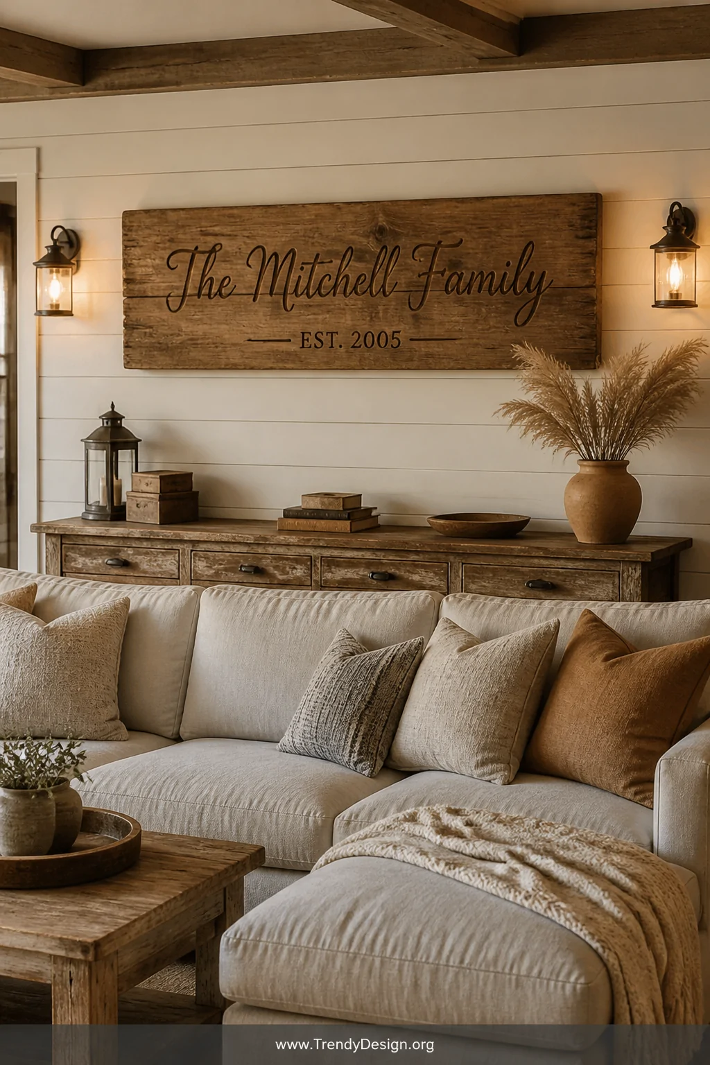 A rustic farmhouse living room with warm amber lighting, featuring a thick reclaimed wooden plank sign with hand-burned scrip