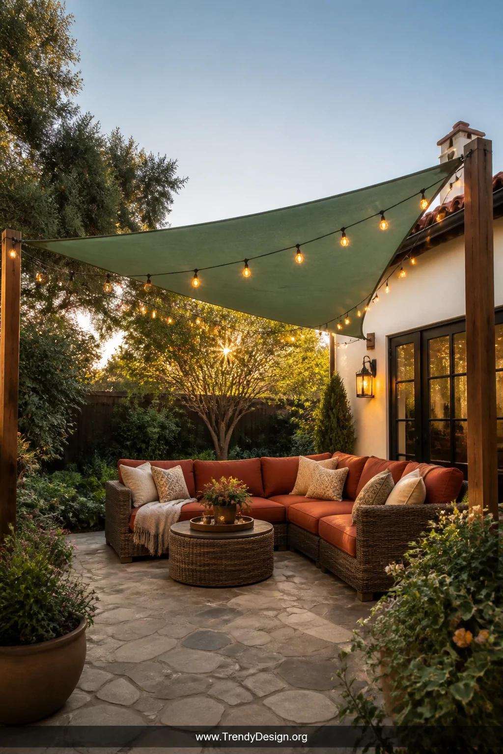 Wide-angle shot of a sun-drenched backyard patio with a taut sage-green polyethylene tarp canopy stretched diagonally between