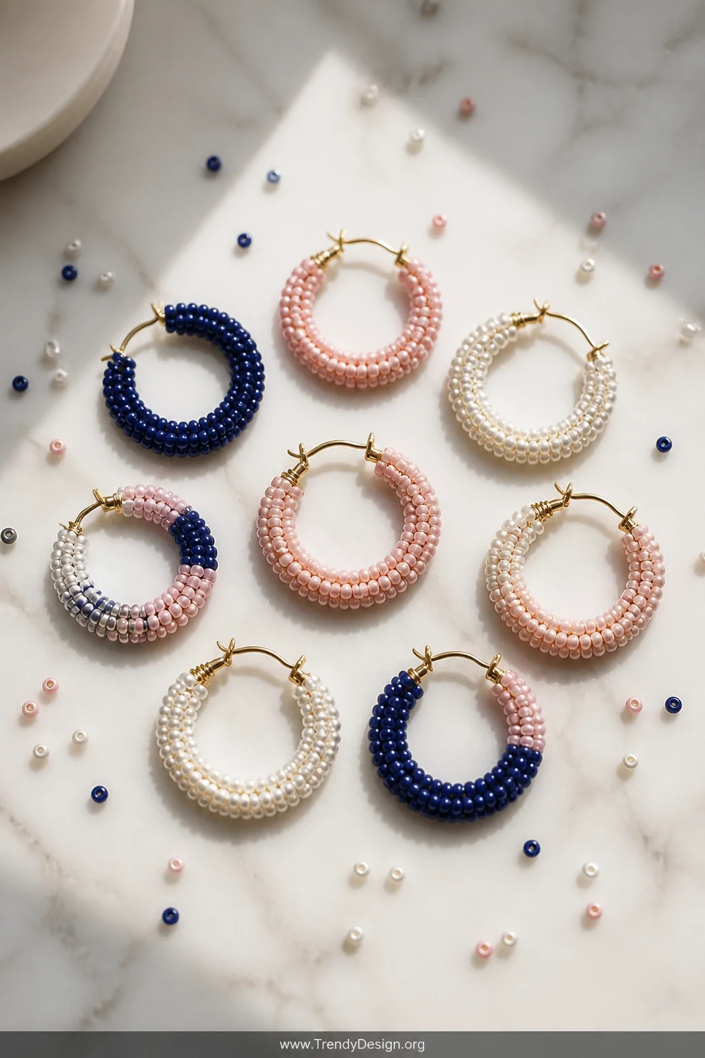 A flat lay styled display on a white marble surface with soft natural window light, showcasing a collection of multicolored t
