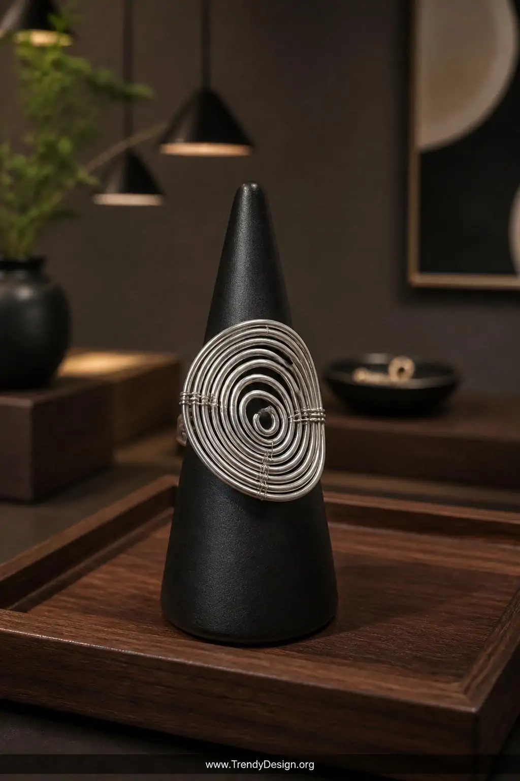 A medium shot of a bold sculptural spiral coil ring formed entirely from silver wire twisted into a dimensional flat spiral, 