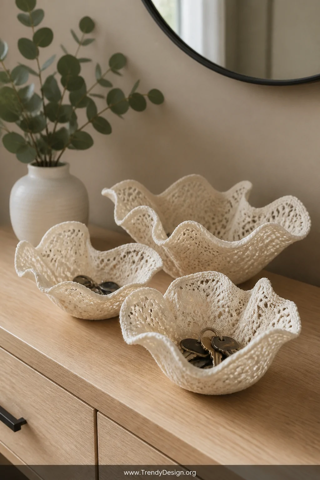 A styled entryway console table in soft morning light showcasing a close-up arrangement of three stiffened cream lace fabric 