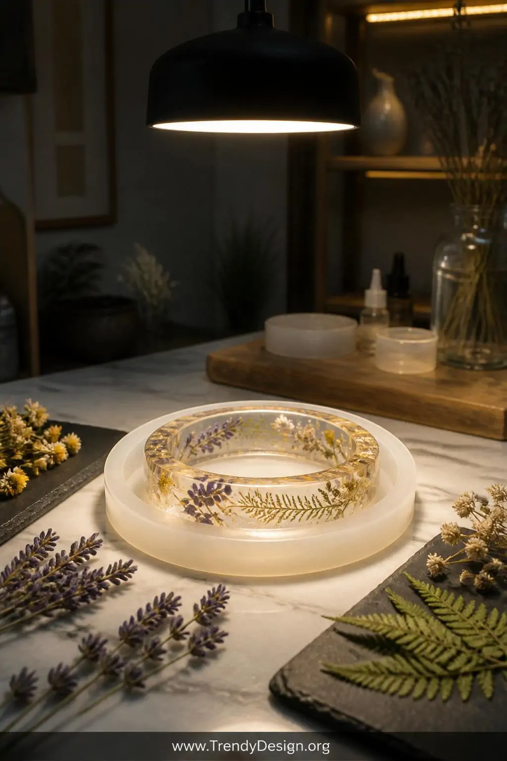 A medium shot captures a marble-topped craft station where a crystal-clear resin bangle sits in a flexible silicone mold surr