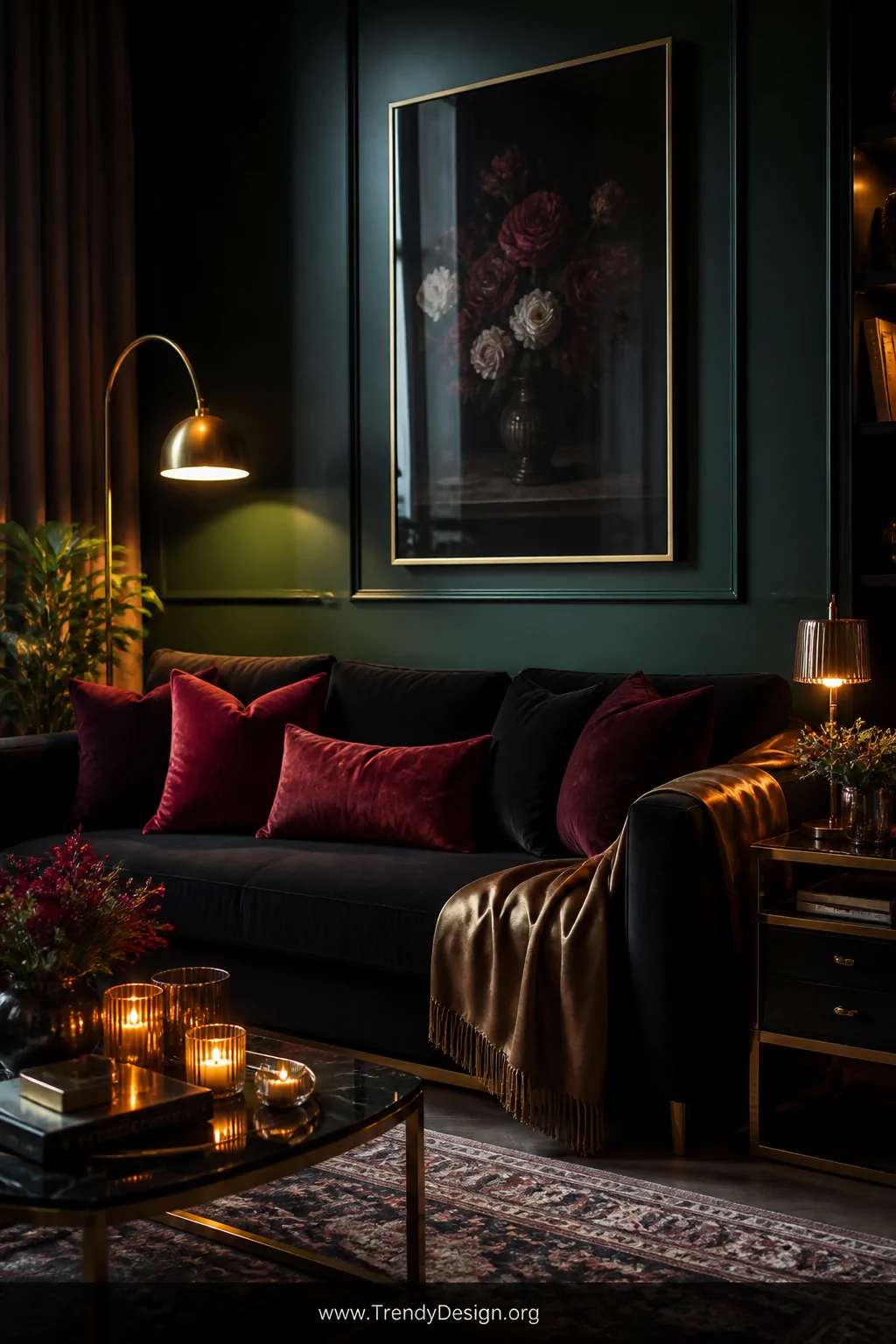 Medium shot of a moody, dramatic living room with a deep charcoal black sofa positioned against dark forest green painted wal