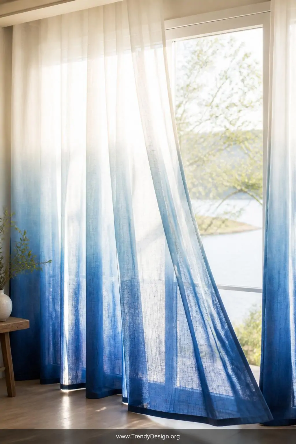 Medium shot of sheer floor-to-ceiling linen curtains with a breathtaking ombre tie dye gradient rising from deep indigo at th