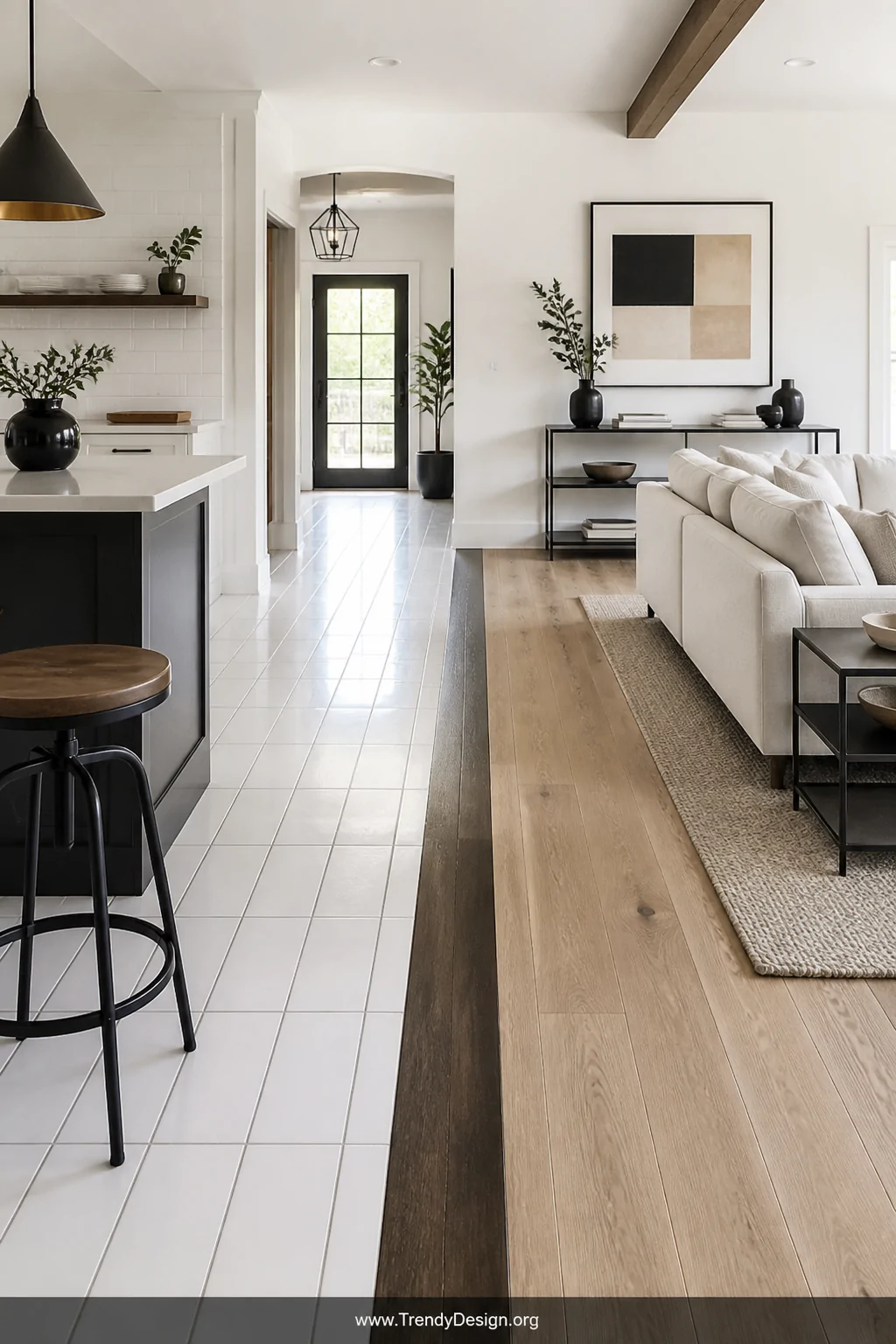 Wide room shot of a bright open-plan space where a bold dark walnut threshold strip acts as a dramatic architectural dividing