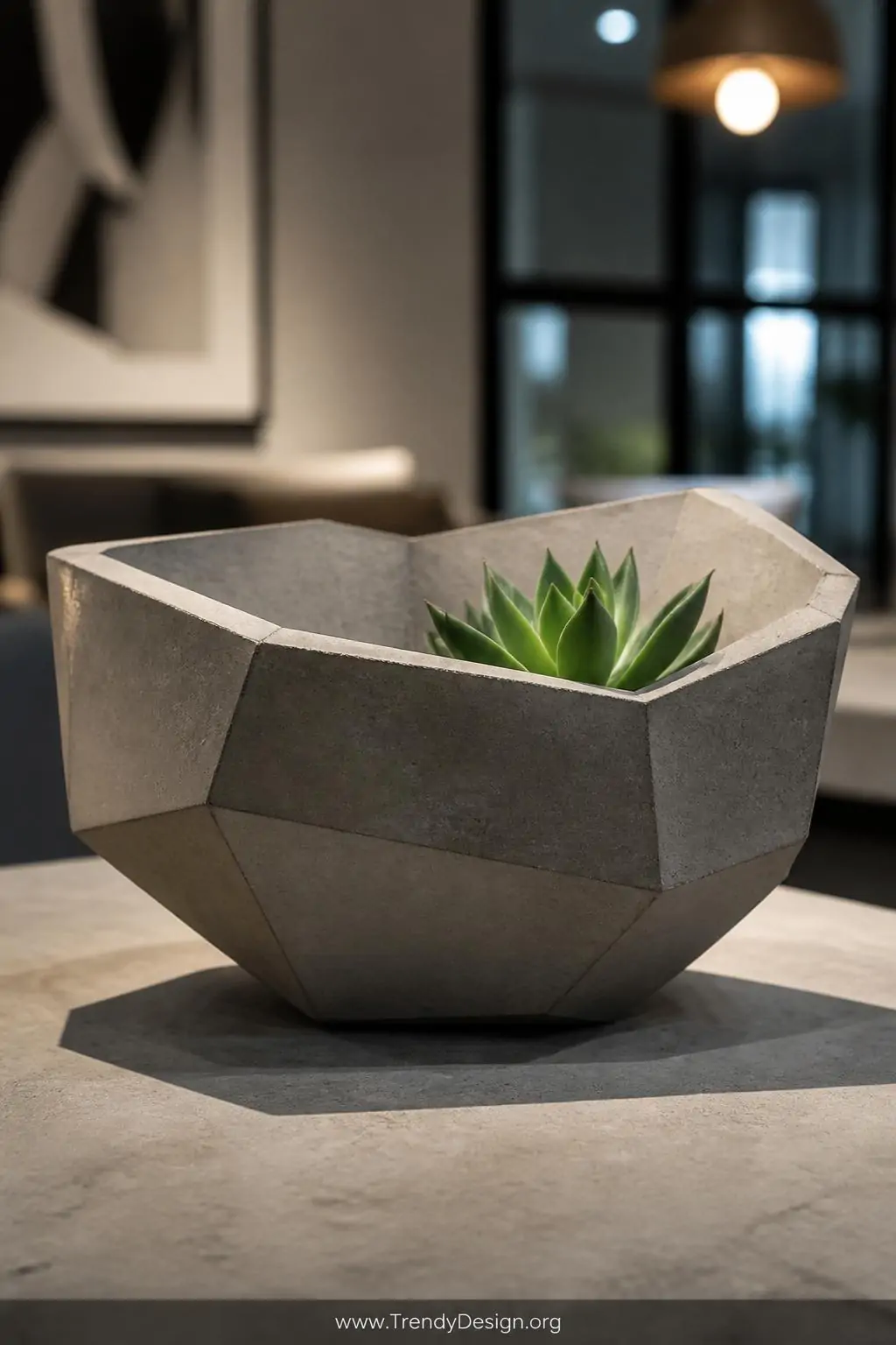 A closeup shot of a sharply angular geometric faceted clay bowl sitting on a concrete coffee table surface, the multi-sided a