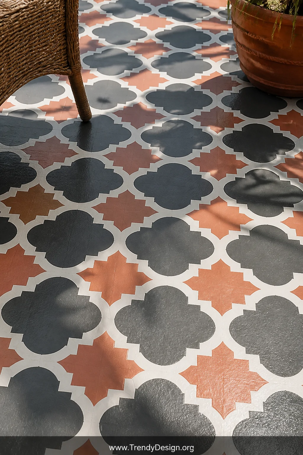Closeup shot of freshly stenciled concrete patio flooring showcasing a bold Moroccan geometric pattern in dusty terracotta an