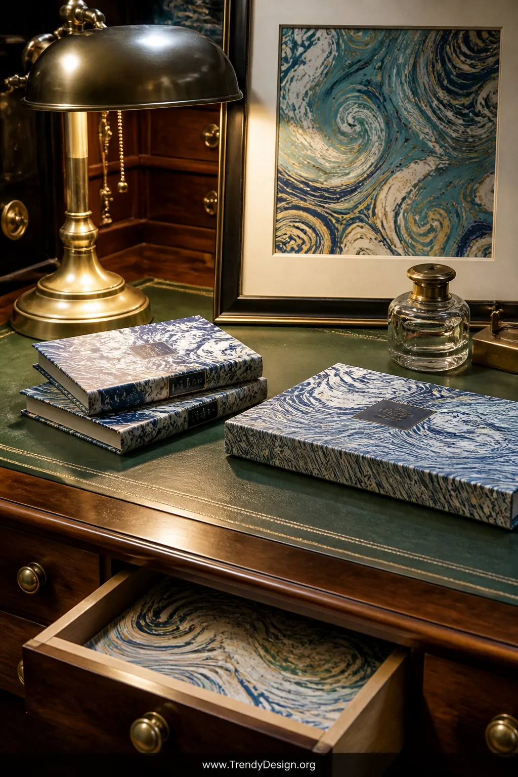Closeup shot of a vintage writing desk surface styled with marbled paper book covers, drawer liners peeking from a half-open 