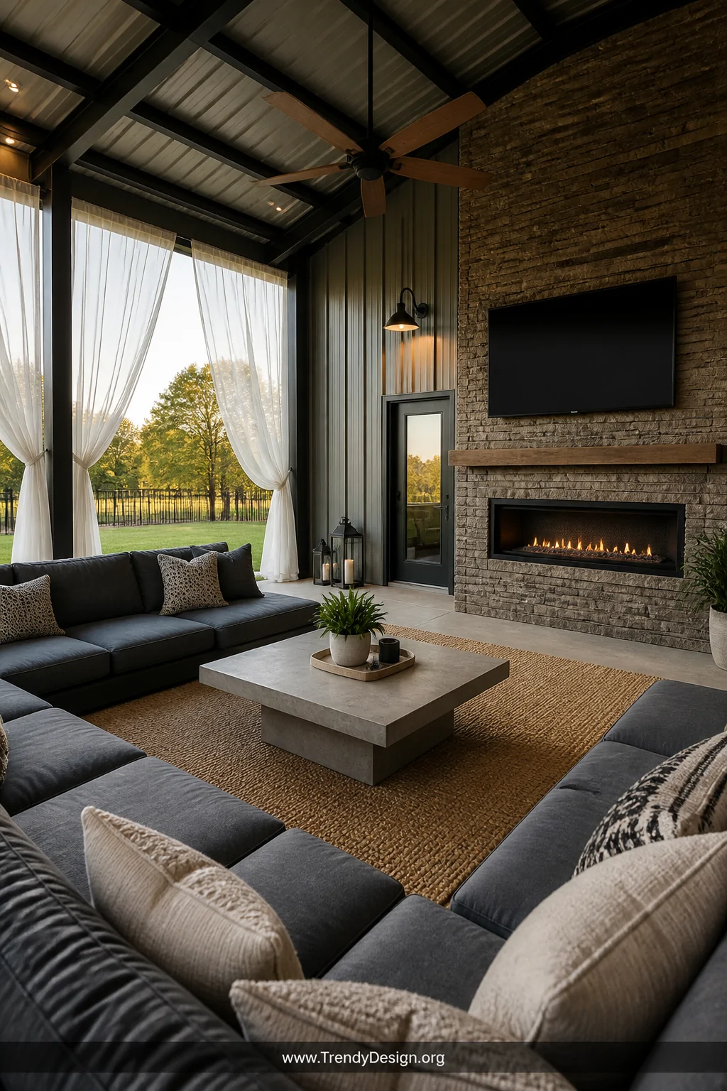 A wide photorealistic interior-style shot of a deeply covered pole barn outdoor living room featuring a large slate-gray sect