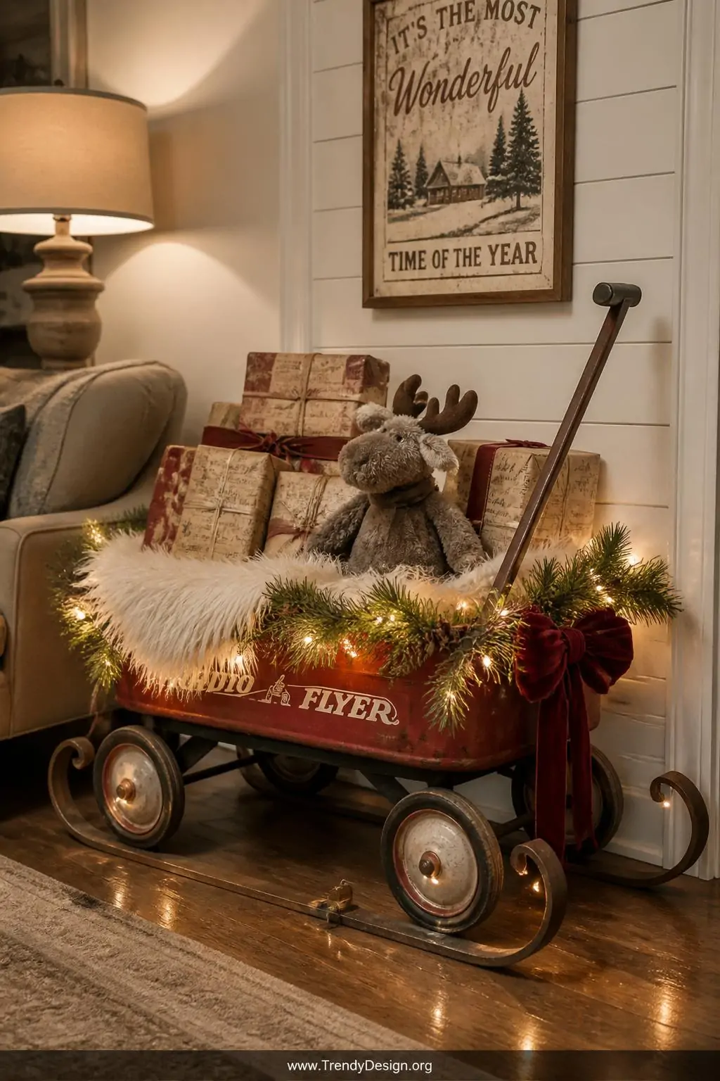 A wide interior shot of a cozy living room corner showcasing a vintage red metal wagon transformed into a holiday sleigh disp