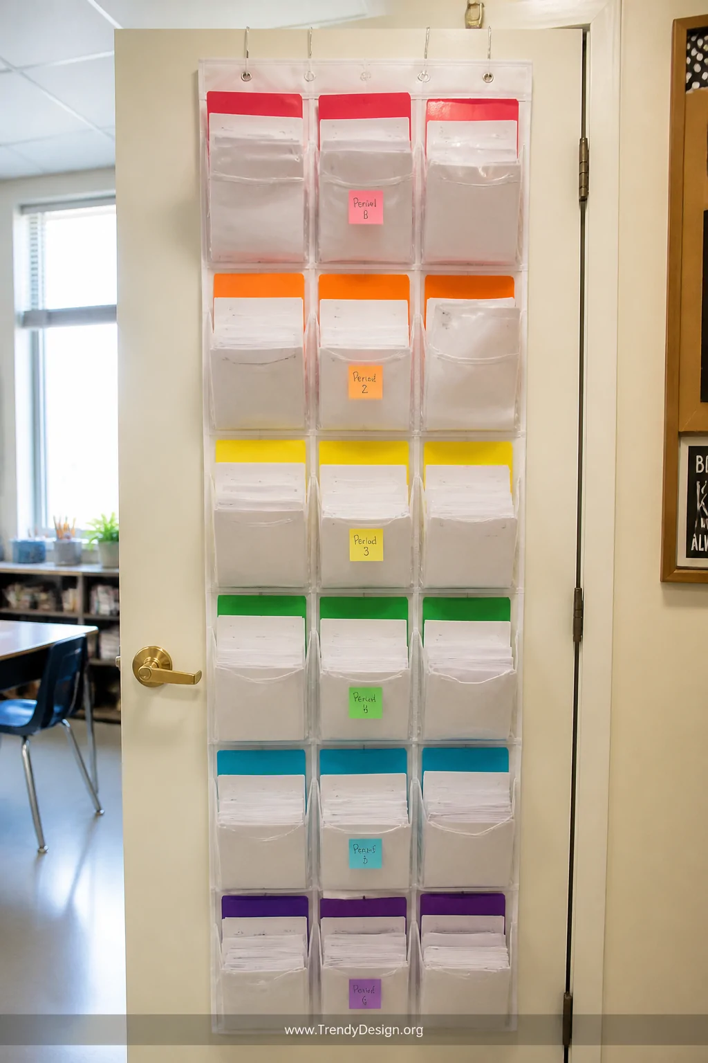 Medium shot of the back of a classroom door fitted with a clear-pocket over-the-door shoe organizer, each transparent pocket 