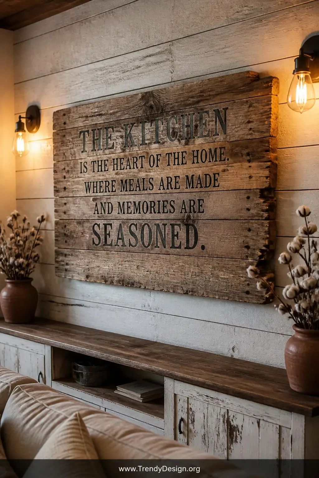 A wide-angle rustic living room wall featuring a large reclaimed pallet wood farmhouse sign with rough uneven grain, visible 