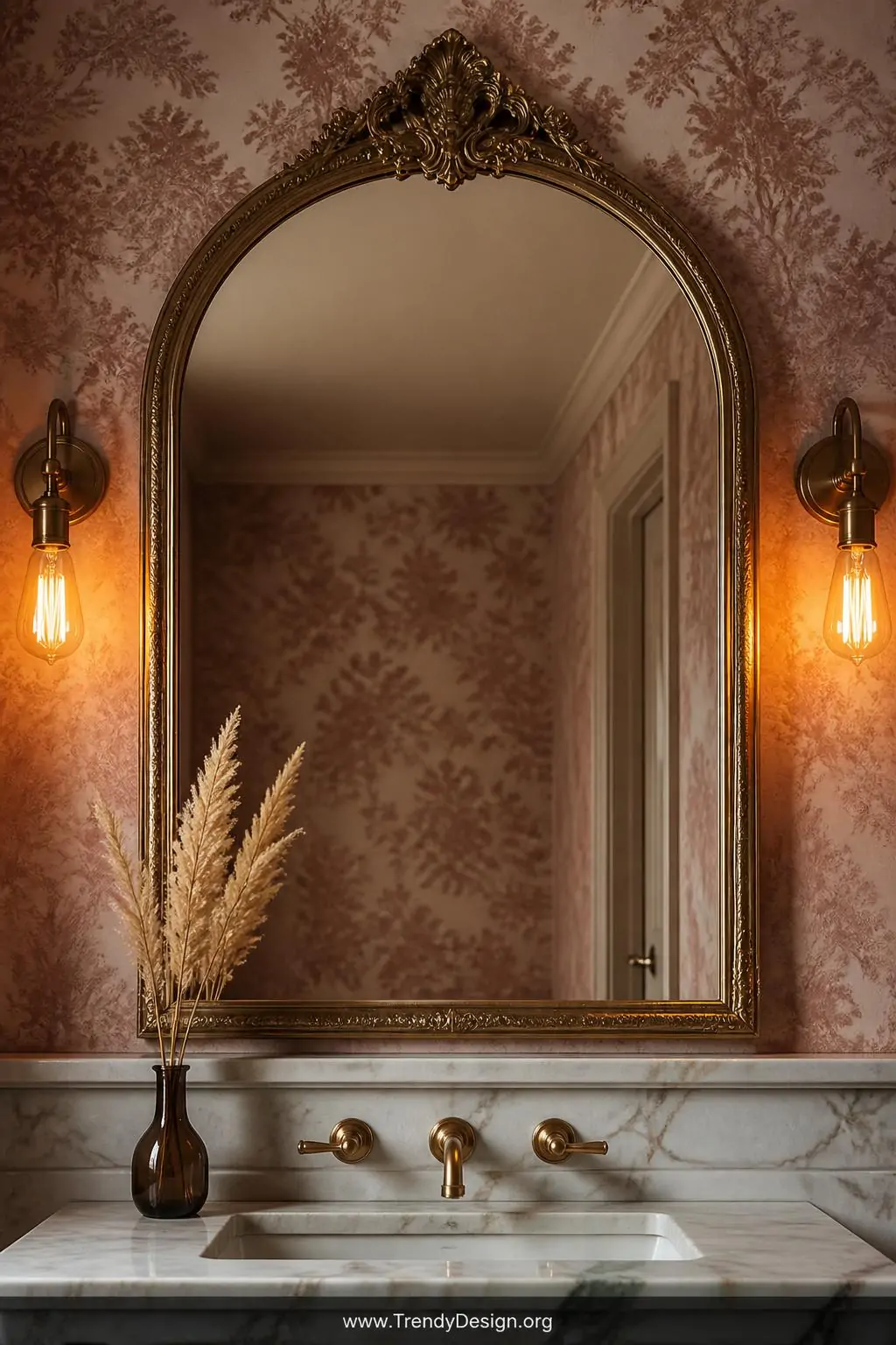 Closeup shot of a large ornate arched mirror with an antique gold carved frame mounted above a marble sink console, the mirro