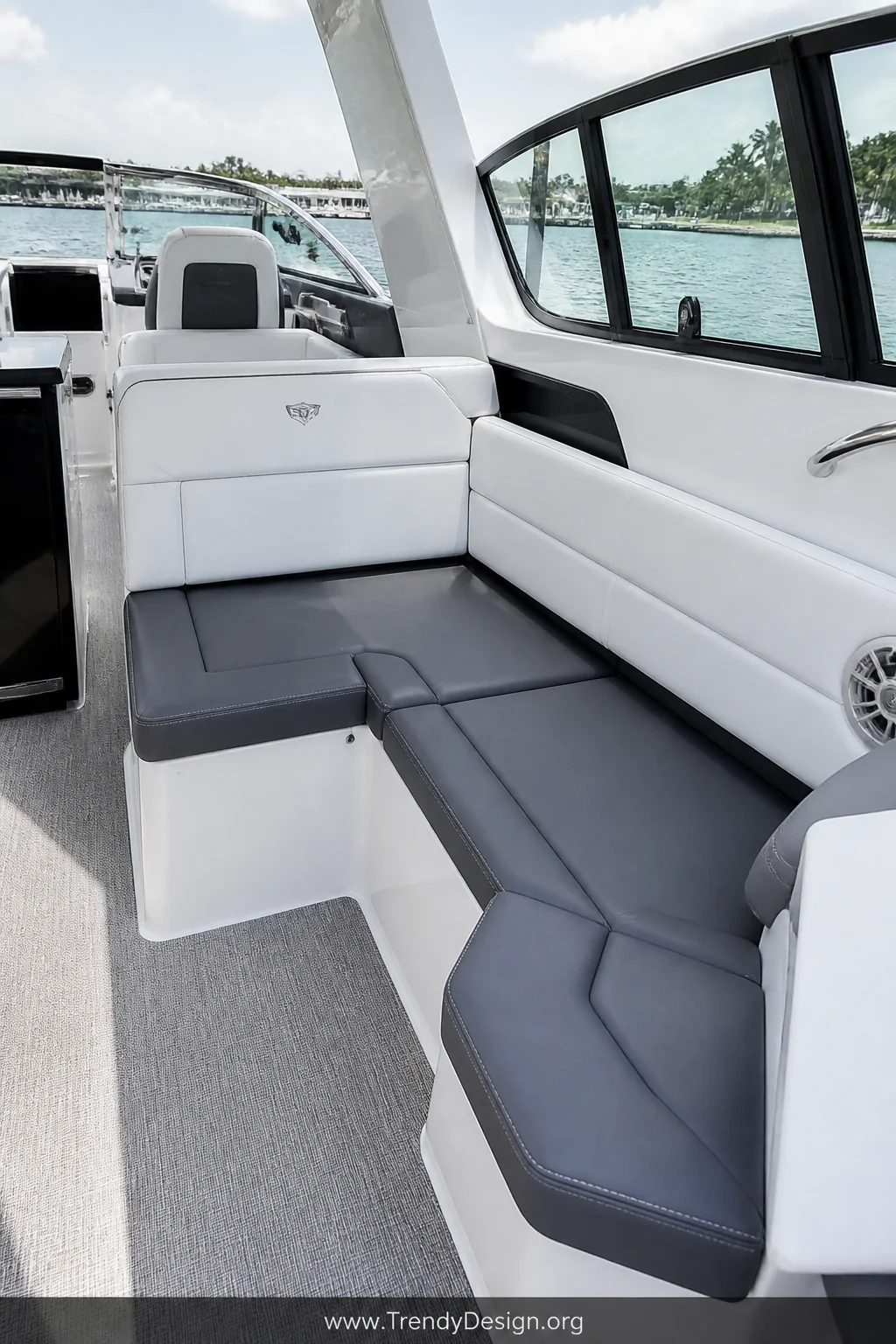 Medium shot of a modern boat interior showcasing color-blocked upholstery with slate gray base cushions paired against crisp 