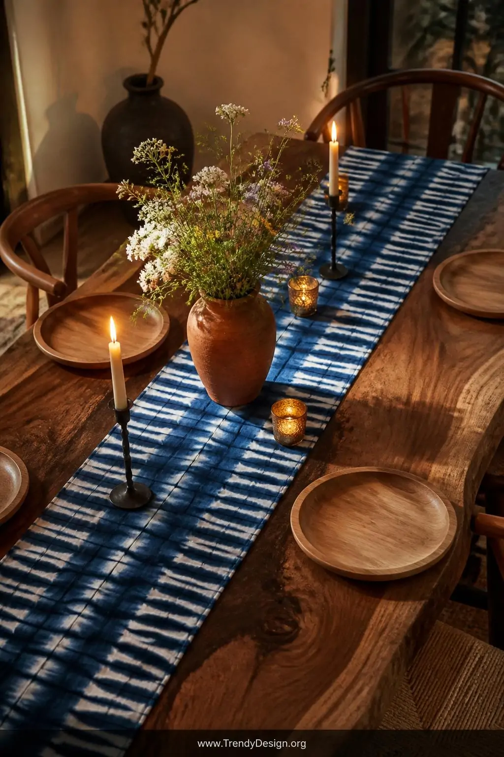 Medium overhead shot of a live-edge walnut dining table dressed with a hand-dyed indigo and white accordion-stripe linen tabl