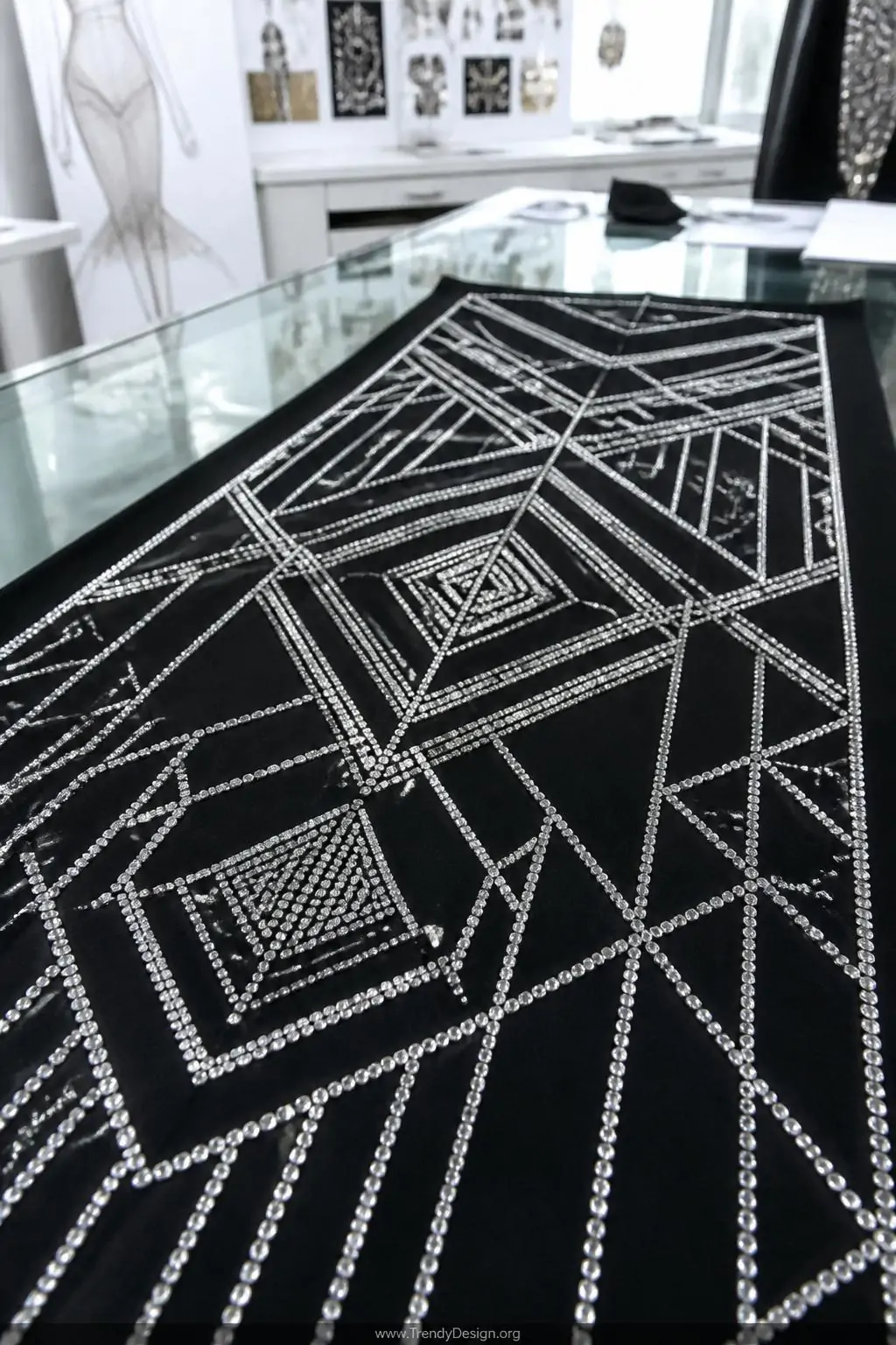A closeup photorealistic detail shot of a sleek black dance costume panel stretched taut across a glass-topped design table u