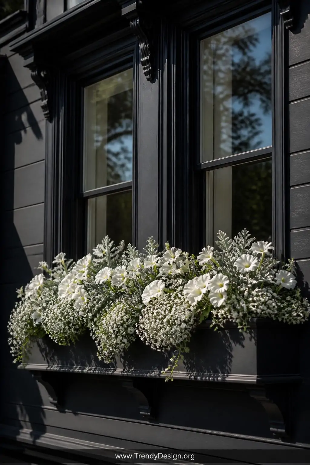 Medium exterior shot of a bold charcoal-gray painted Victorian home facade with a stunning all-white window box display featu