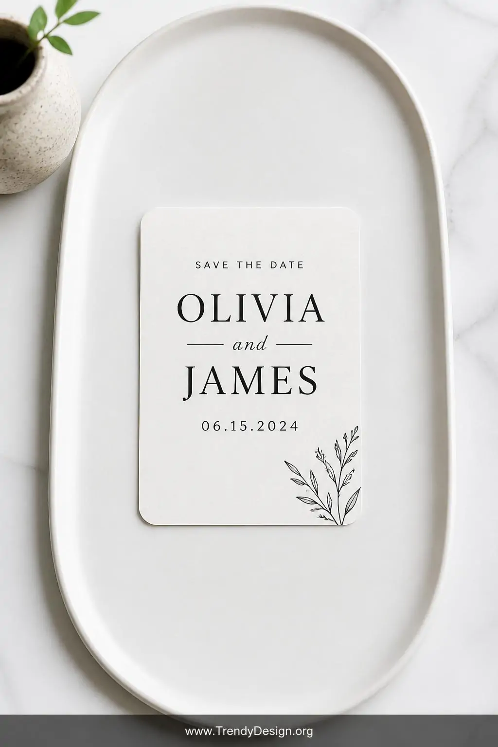 A closeup shot of a minimalist typography save the date magnet centered on a smooth matte white ceramic tray, bold high-contr