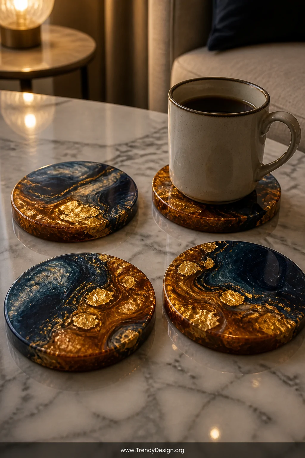 Close-up detail shot of four resin coasters arranged on a marble coffee table, each one uniquely swirled with deep navy, gold