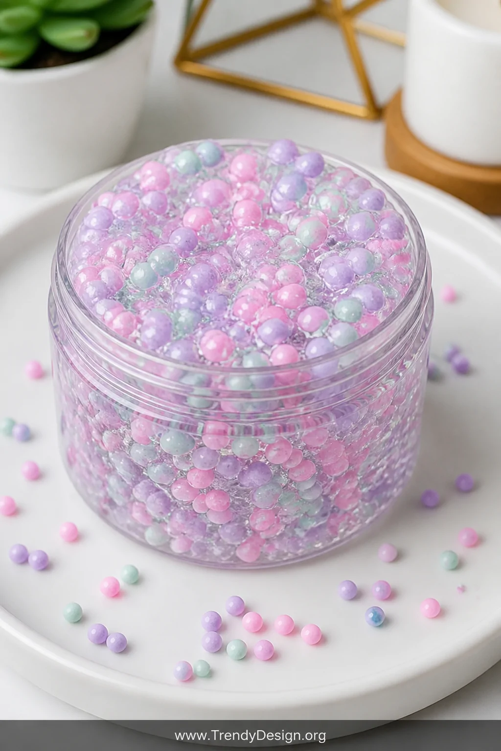 A vibrant medium detail shot of an open container of floam-style clear slime densely packed with pastel-colored mini foam bea