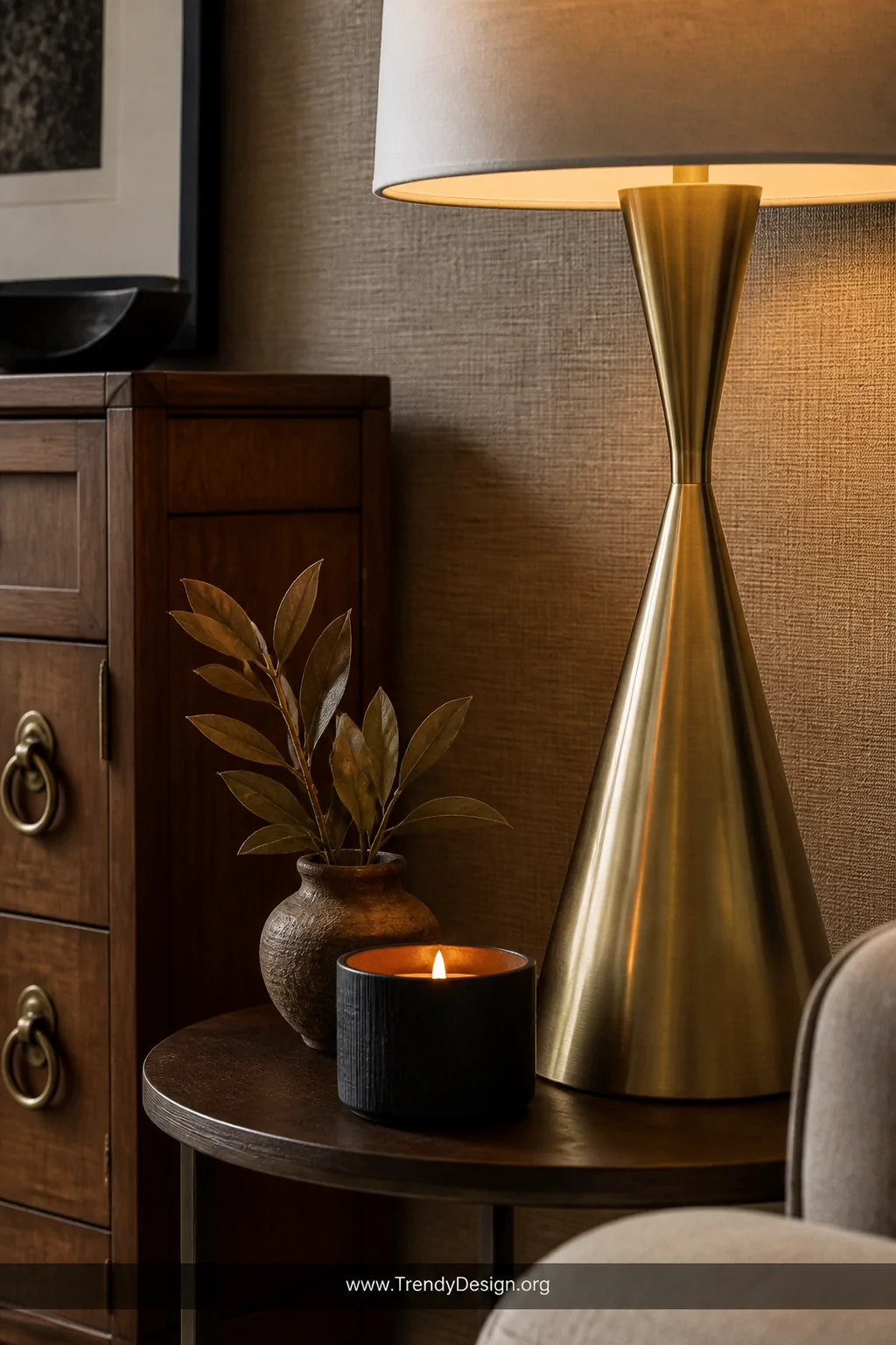 Detail closeup photorealistic shot of a styled side table and floor lamp vignette featuring a brushed gold lamp base, antique