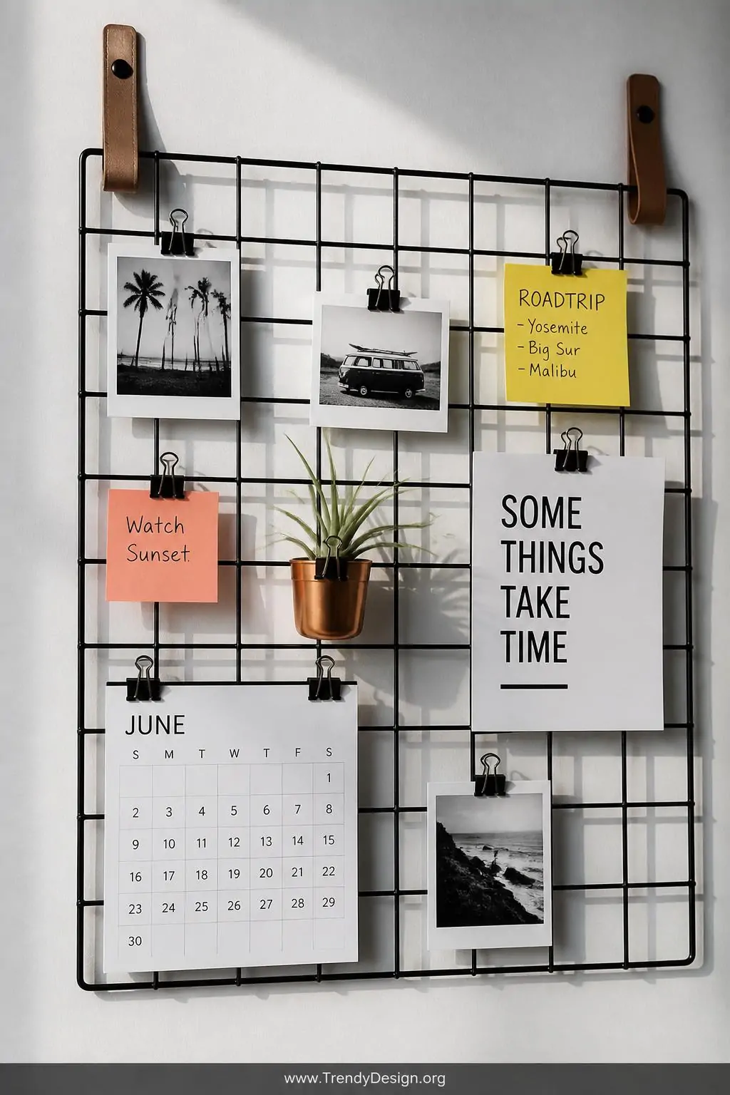 A closeup photorealistic interior design image of a sleek black wire grid memo board mounted on a soft white wall with visibl