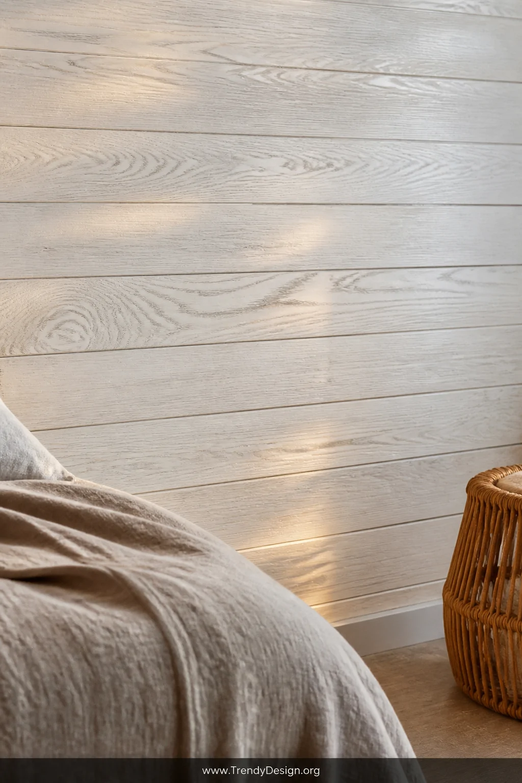 Detail closeup of a bedroom wall with whitewashed wood planks showing visible natural grain beneath a soft translucent white 