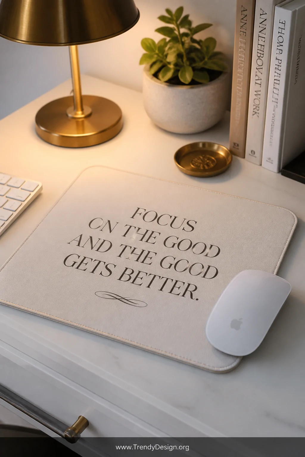 A closeup detail shot of a clean white desk surface featuring a mousepad with elegant serif typography displaying a single me
