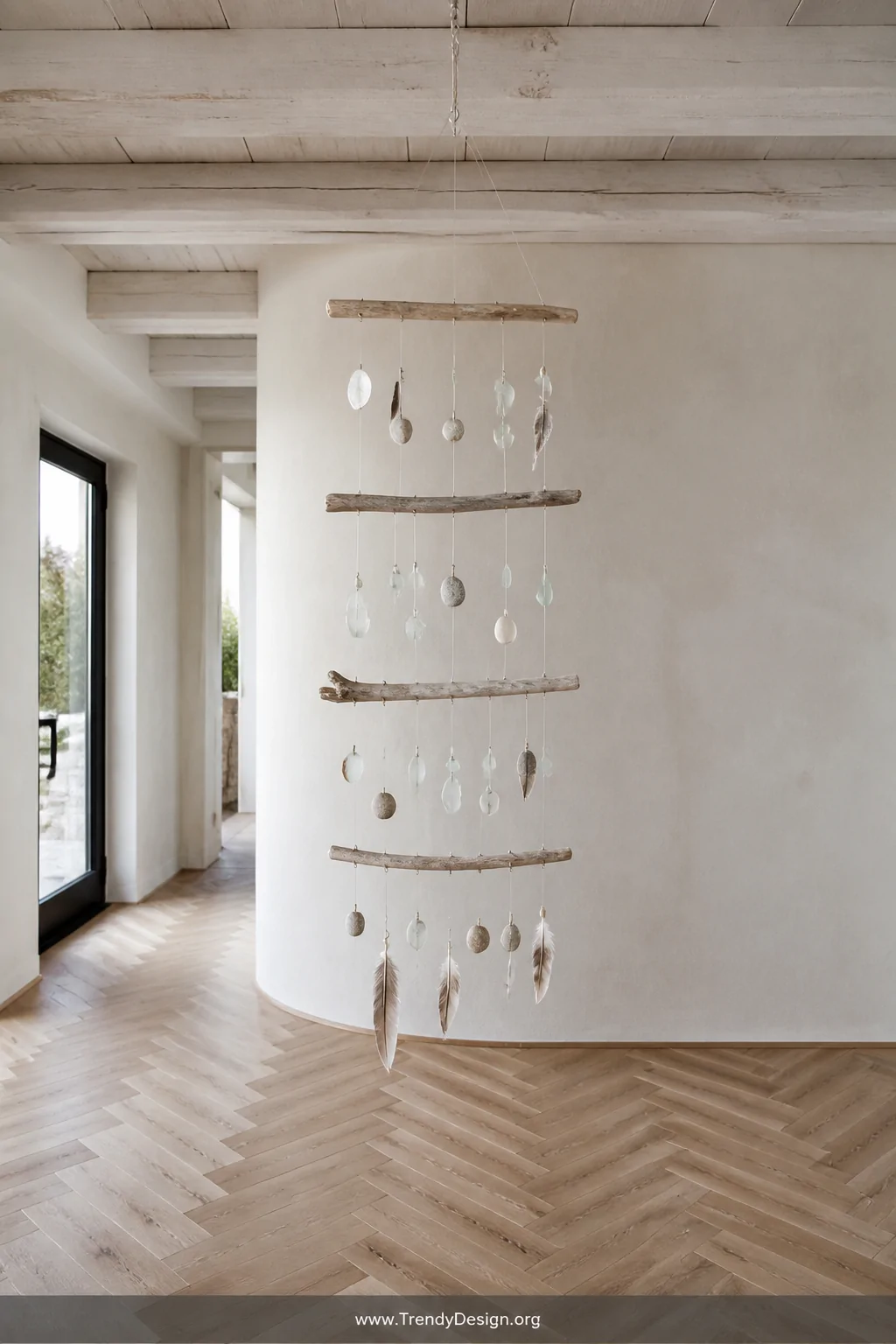 A wide-shot photorealistic interior of a minimalist entryway featuring a layered driftwood and stone mobile suspended from a 
