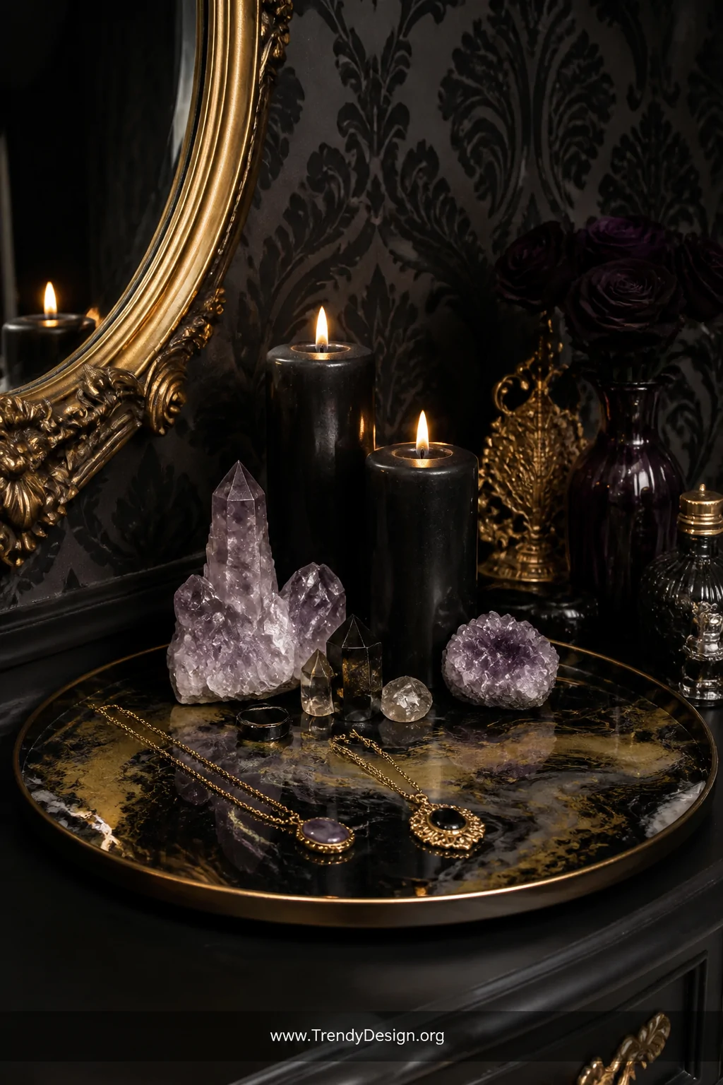 Wide shot of a gothic styled vanity altar vignette featuring a large black and gold swirled resin tray holding tall black pil