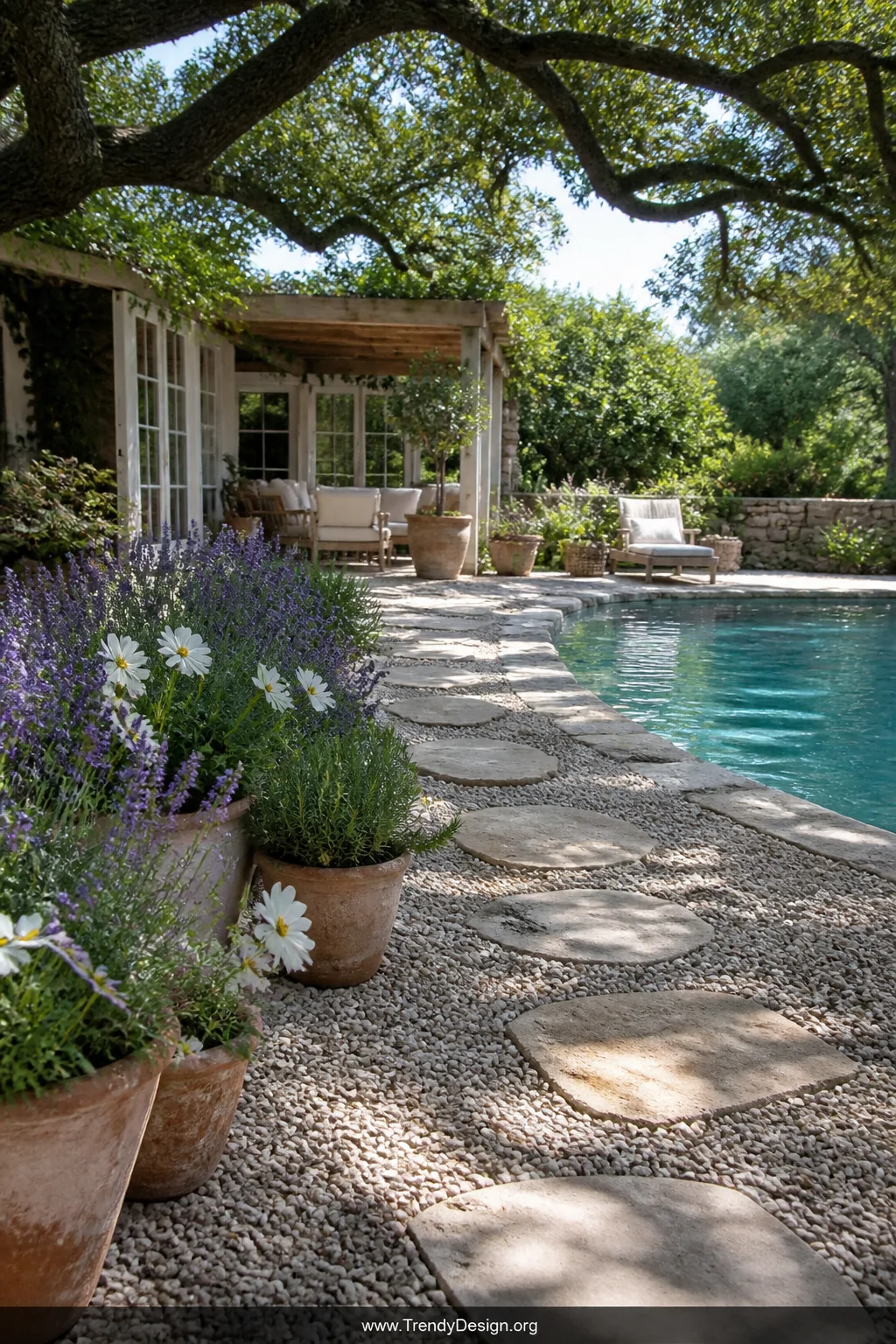 Wide photorealistic shot of a relaxed cottage-garden backyard pool surrounded by smooth rounded pea gravel in soft dove-grey 