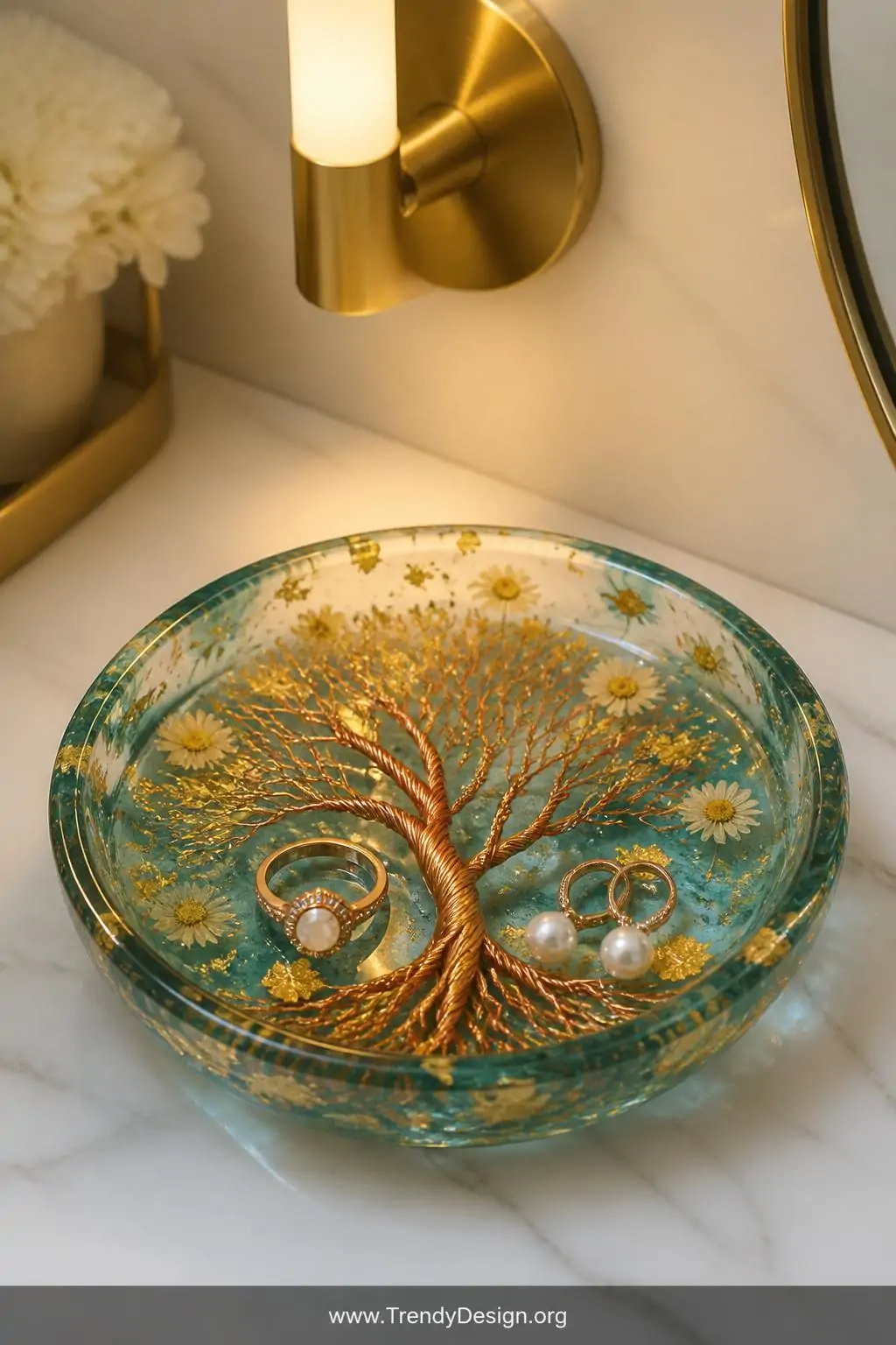 A dramatic closeup of a finished resin Tree of Life jewelry dish resting on a white marble vanity surface, the translucent te