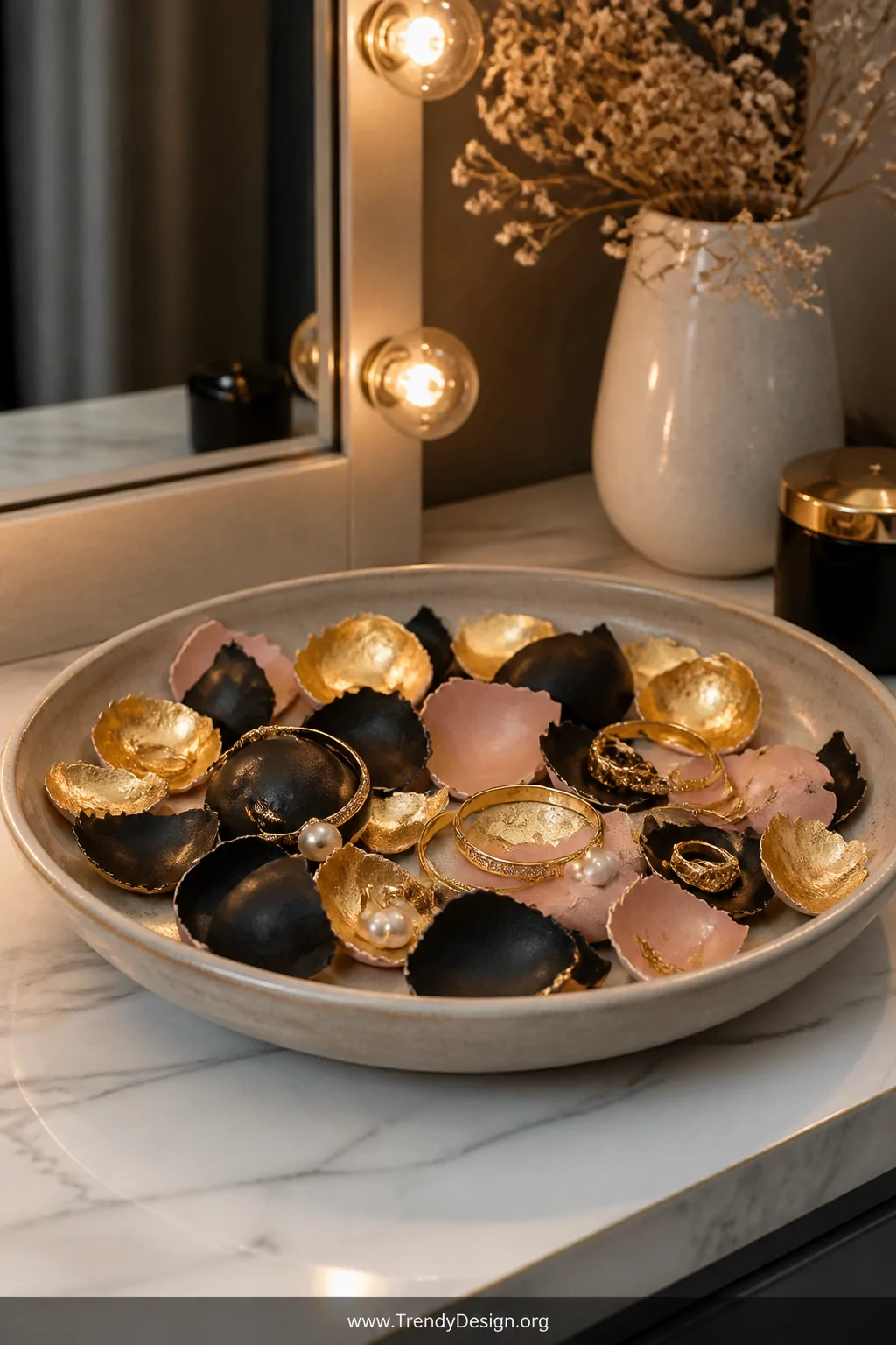 Close-up detail shot of a vanity dresser surface featuring a wide shallow ceramic dish filled with artfully layered broken eg
