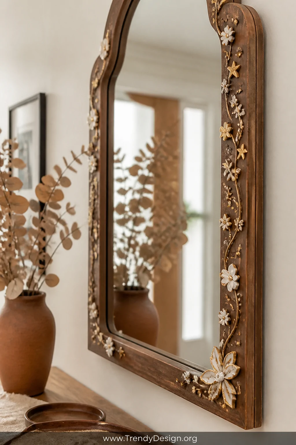 Detail closeup shot of a thrift store wooden mirror hanging in a warm entryway, its frame adorned with handcrafted polymer cl