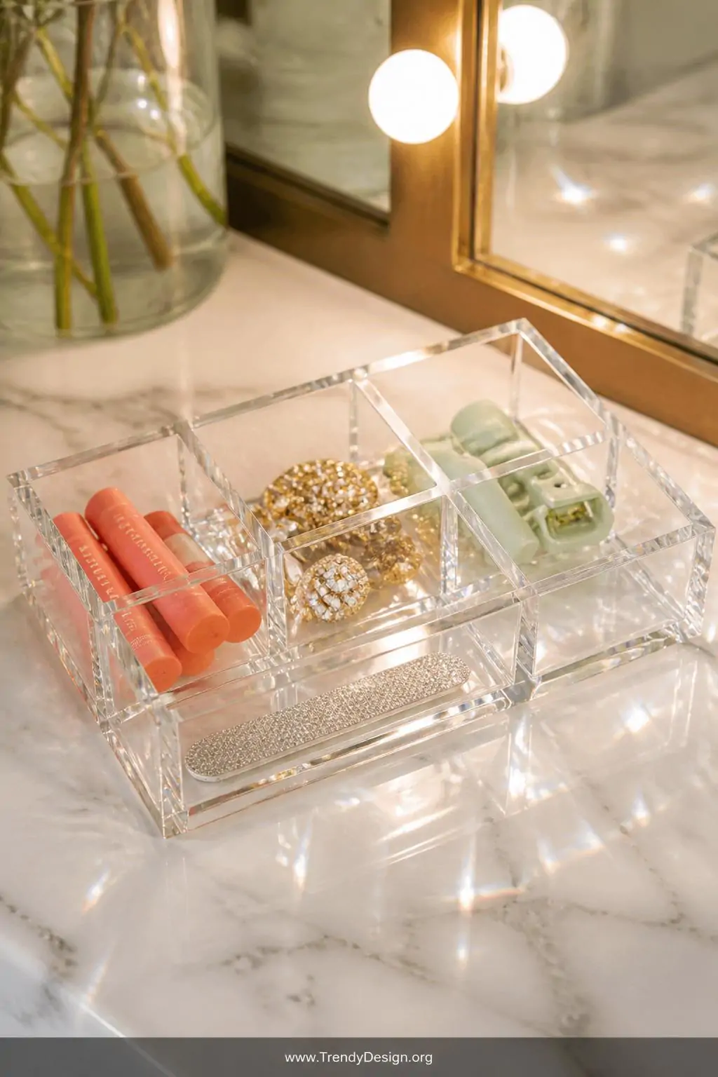 Closeup shot of a slim clear acrylic drawer organizer sitting directly on a white marble countertop, individual grid sections
