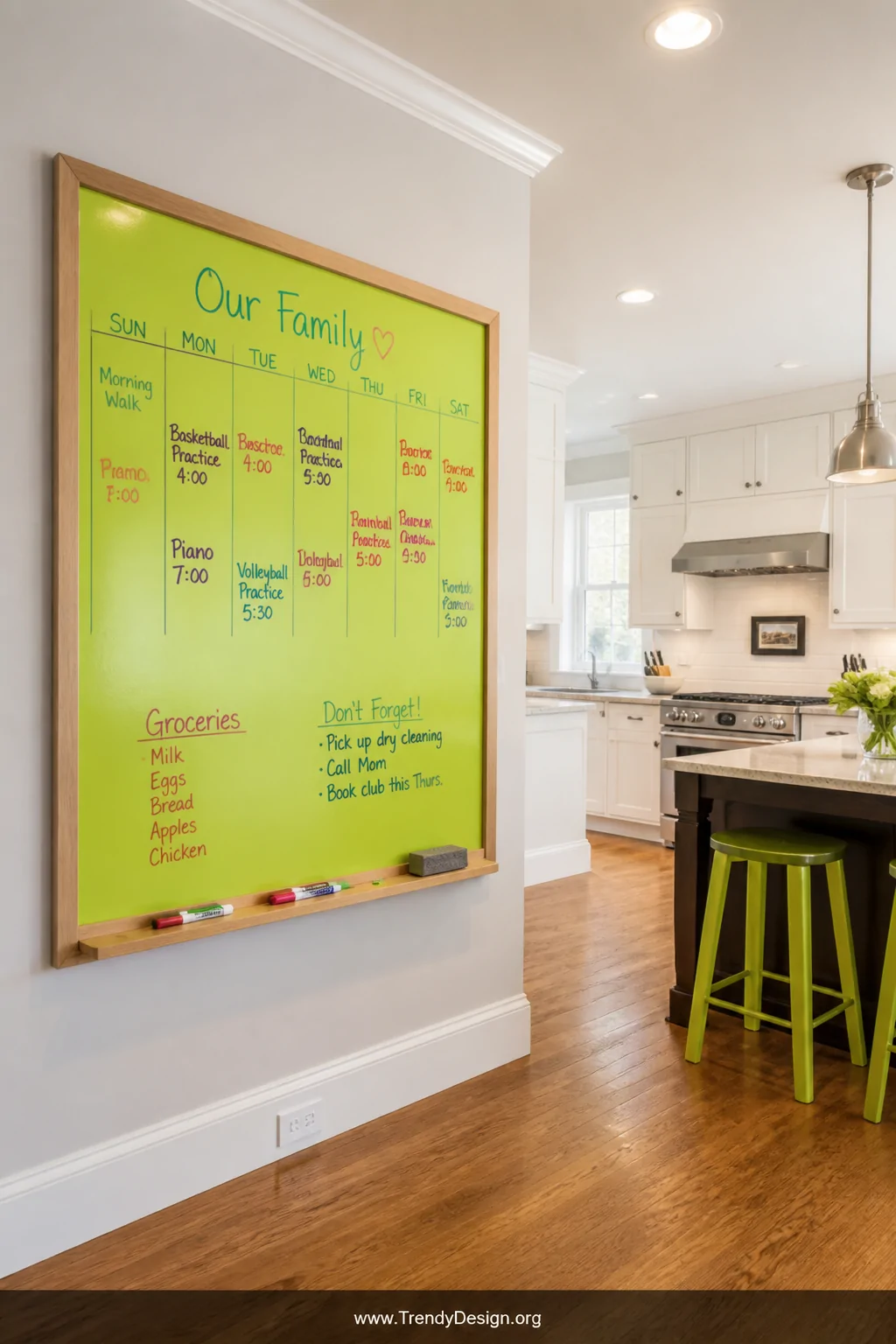 A wide bright family kitchen shot featuring a bold lime green whiteboard apron board framed in a natural light oak wood borde