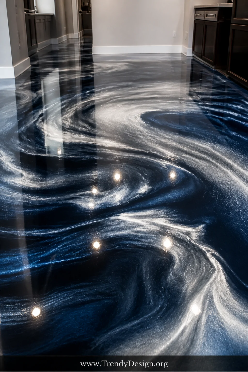 Closeup wide-angle shot of a dramatic swirling metallic epoxy floor in deep navy, liquid silver, and pearl white, the high-gl