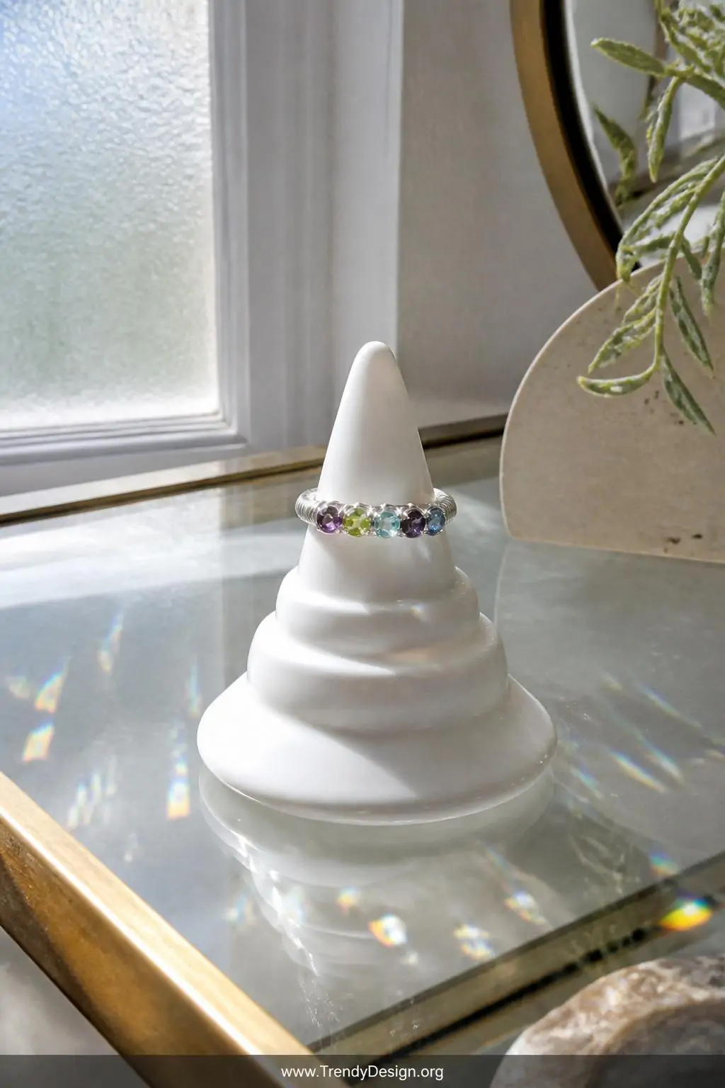 A medium shot of a multi-stone row ring lined with five tiny faceted gems in amethyst, peridot, and blue topaz wrapped in fin