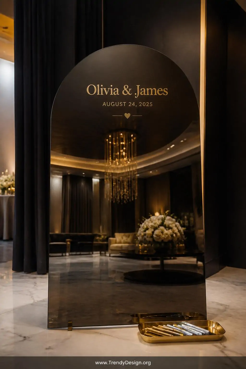 Wide shot of a large arch-shaped smoked mirrored acrylic guest board standing on a white marble floor, names and wedding date