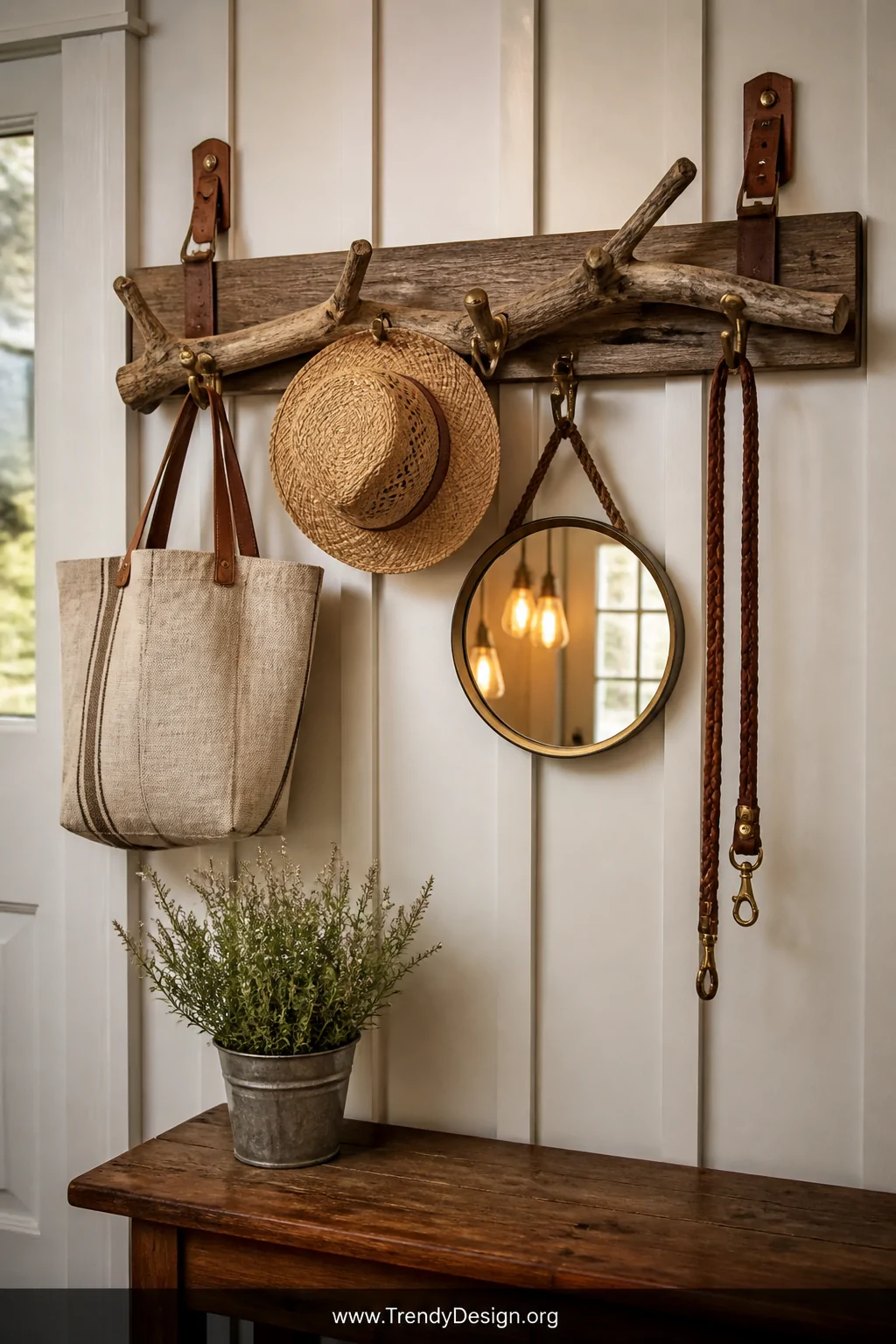 A charming entryway vignette centered on a 30-inch weathered oak branch coat rack mounted horizontally on a board-and-batten 