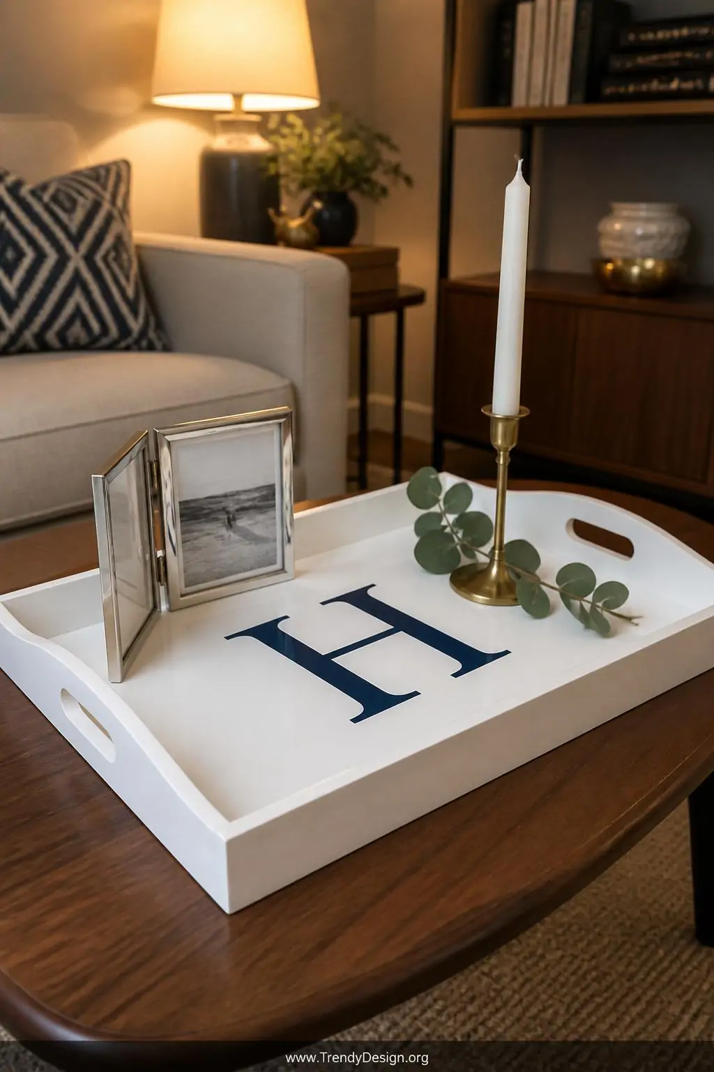 Medium shot of a smooth painted white wooden tray featuring a large crisp navy blue stenciled monogram letter centered on its