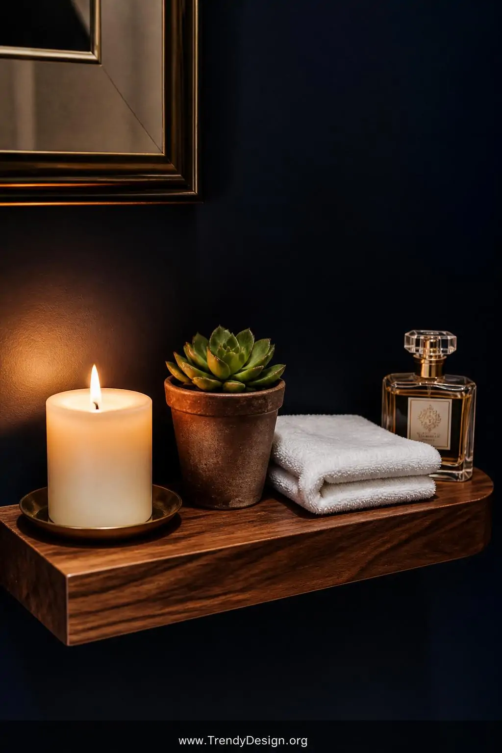 A small floating walnut shelf styled as an intimate spa vignette holding a cream pillar candle, a tiny potted succulent in a 