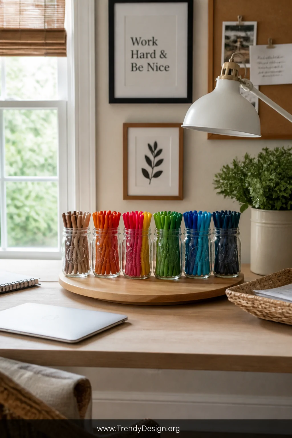 A wide shot of a tidy craft desk with a wooden lazy Susan holding six matching small mason jars filled with color-sorted mark