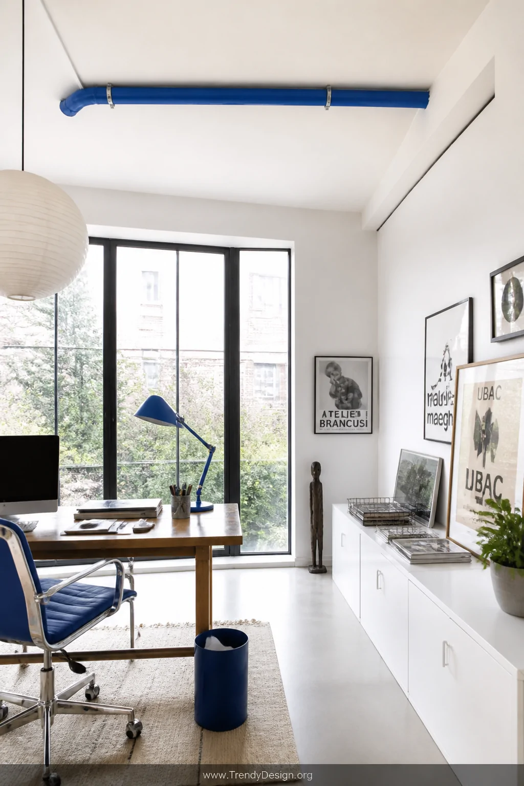 Medium shot of a vibrant home studio or creative office where a single run of bold cobalt blue conduit cuts across an otherwi