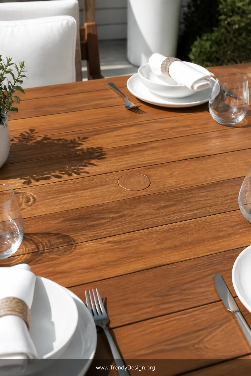 A medium close-up shot of a rectangular teak outdoor dining table with a perfectly flush-fitted teak wood umbrella hole plug 