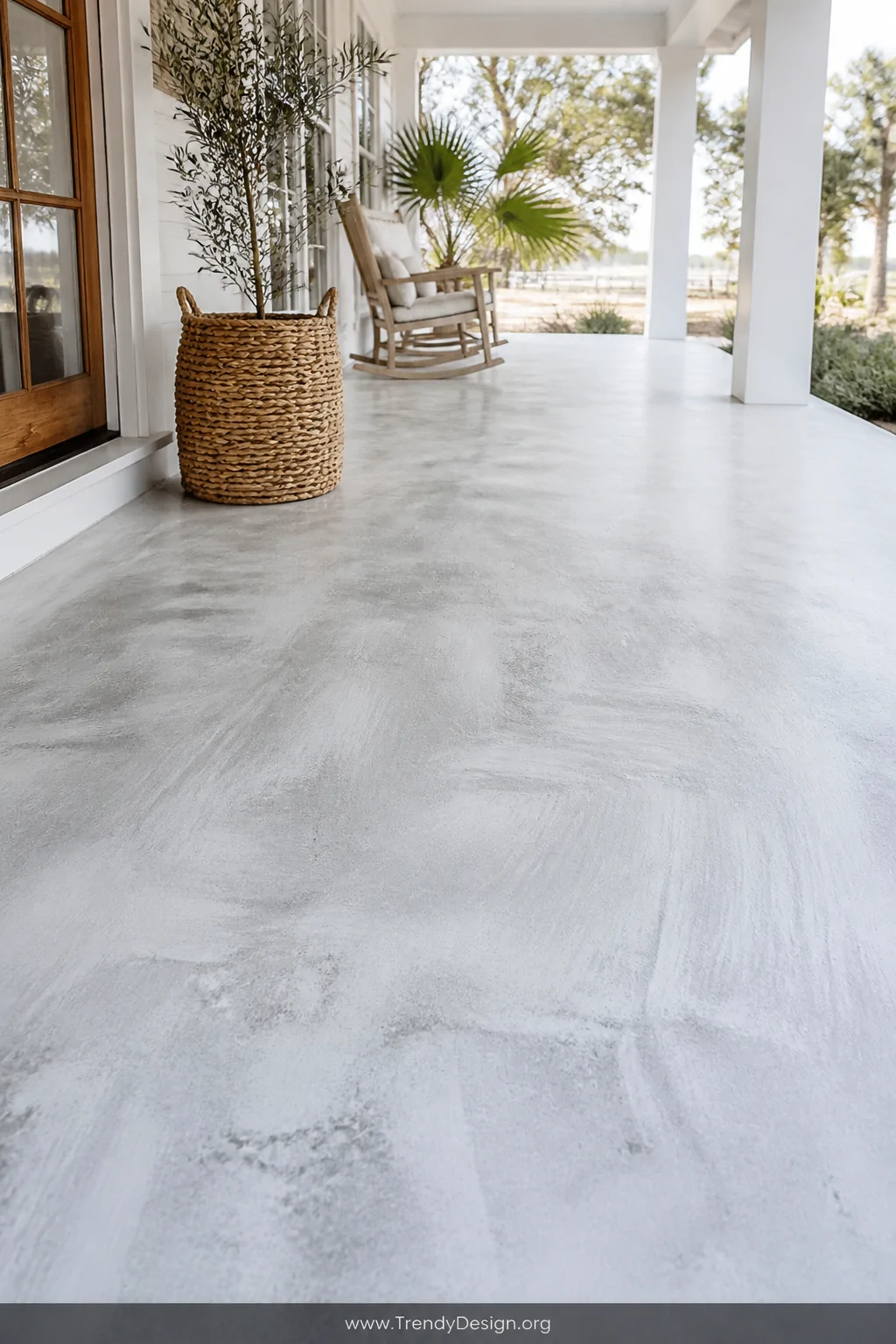 Medium shot of a whitewashed concrete porch floor with thin translucent layers of diluted white paint brushed in long sweepin