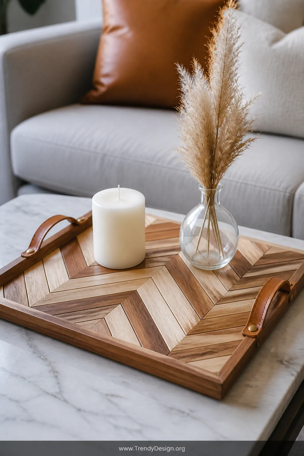 A close-up detail shot of a handmade herringbone serving tray resting on a marble coffee table, wood slats cut into short equ