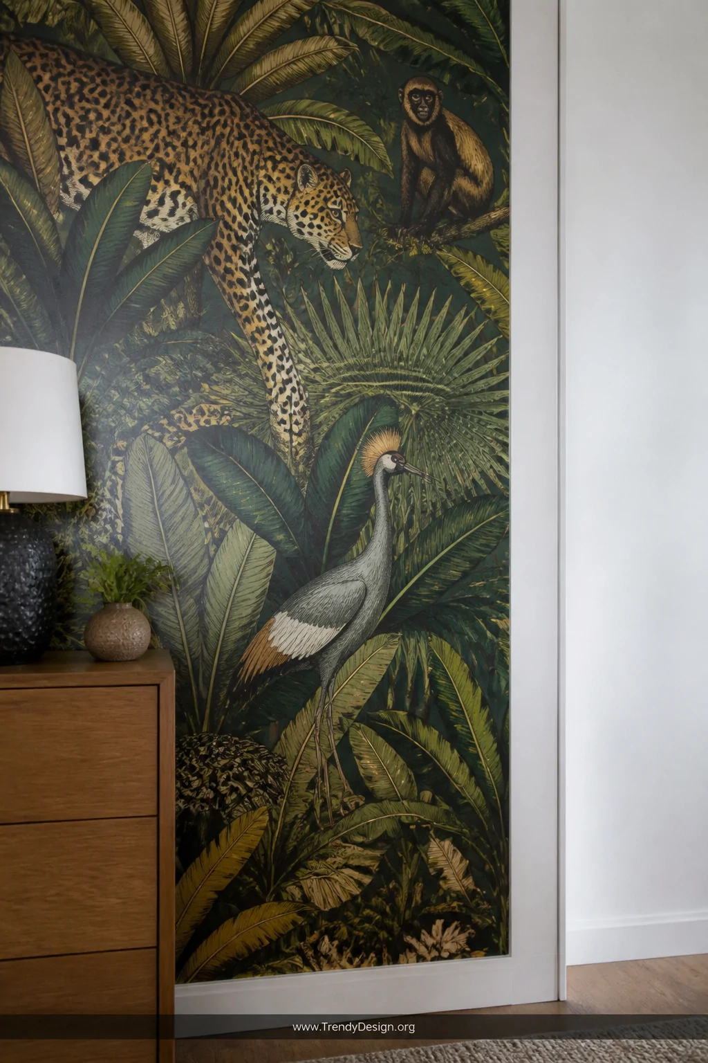 Close-up detail shot of a single accent wall covered in large-scale removable wallpaper featuring bold jungle animals and lus