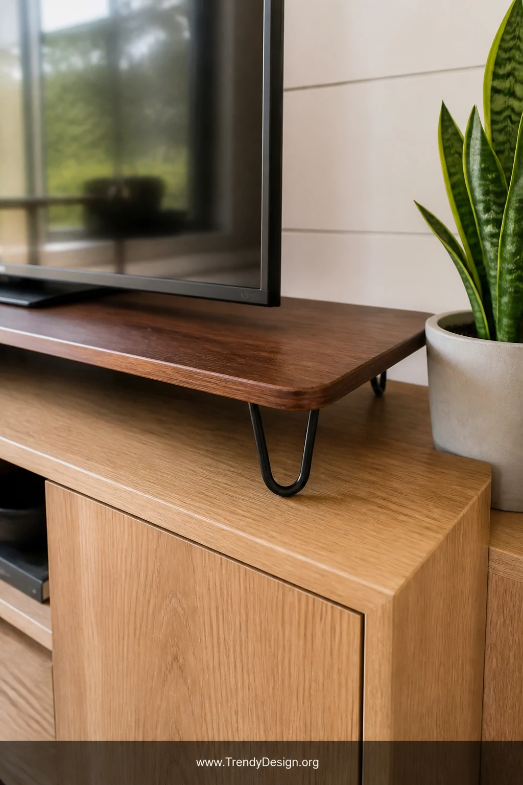 A detail shot of a smooth walnut-stained plywood platform riser sitting flush atop a white oak media console, hairpin legs vi