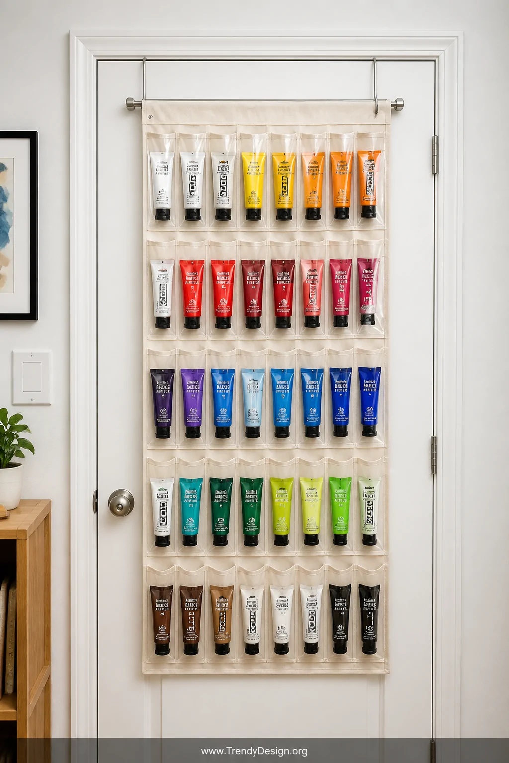 Medium shot of a hanging canvas pocket organizer suspended from a slim curtain rod mounted on the back of a white painted doo
